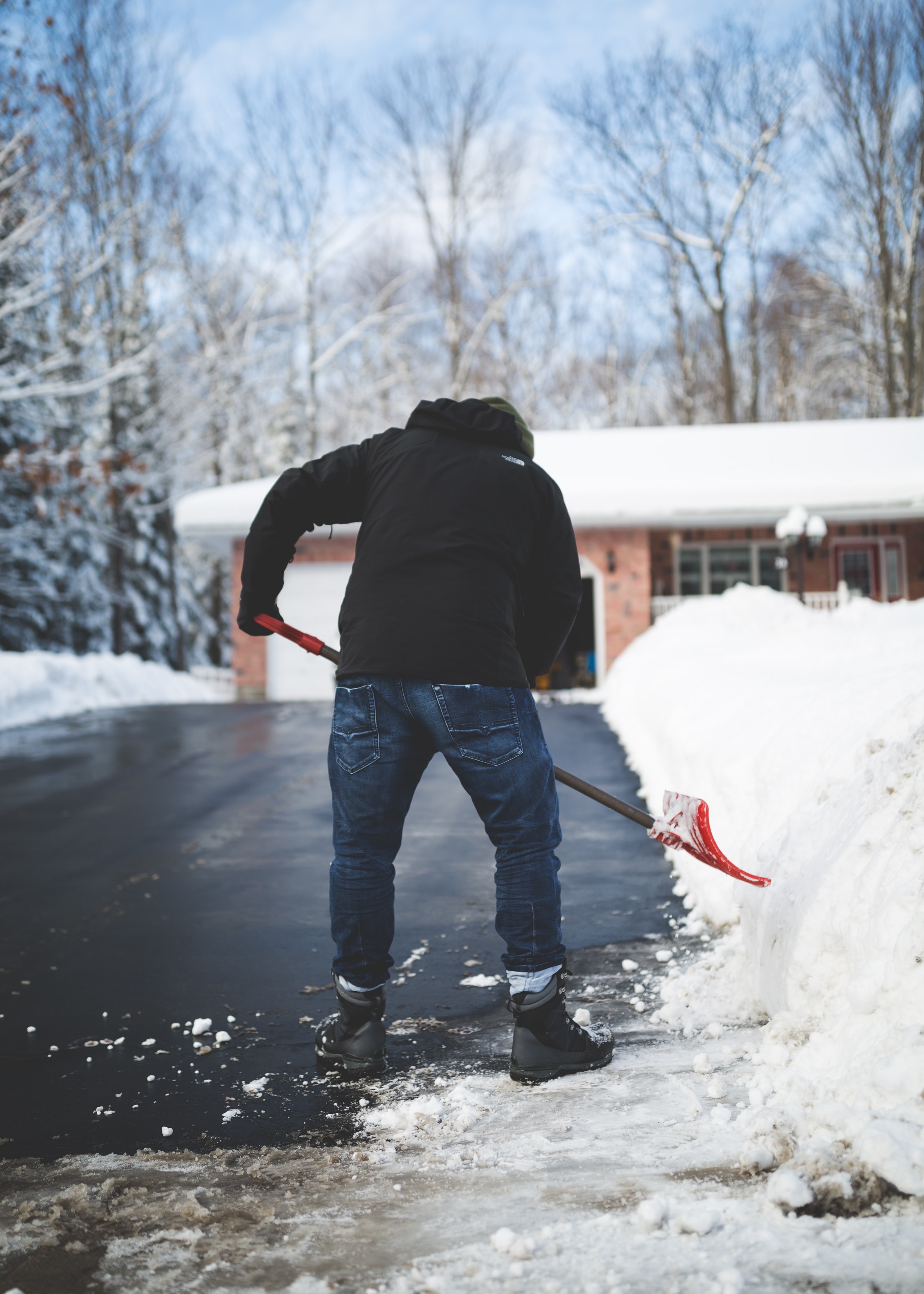 Man shoveling snow off of a driveway.